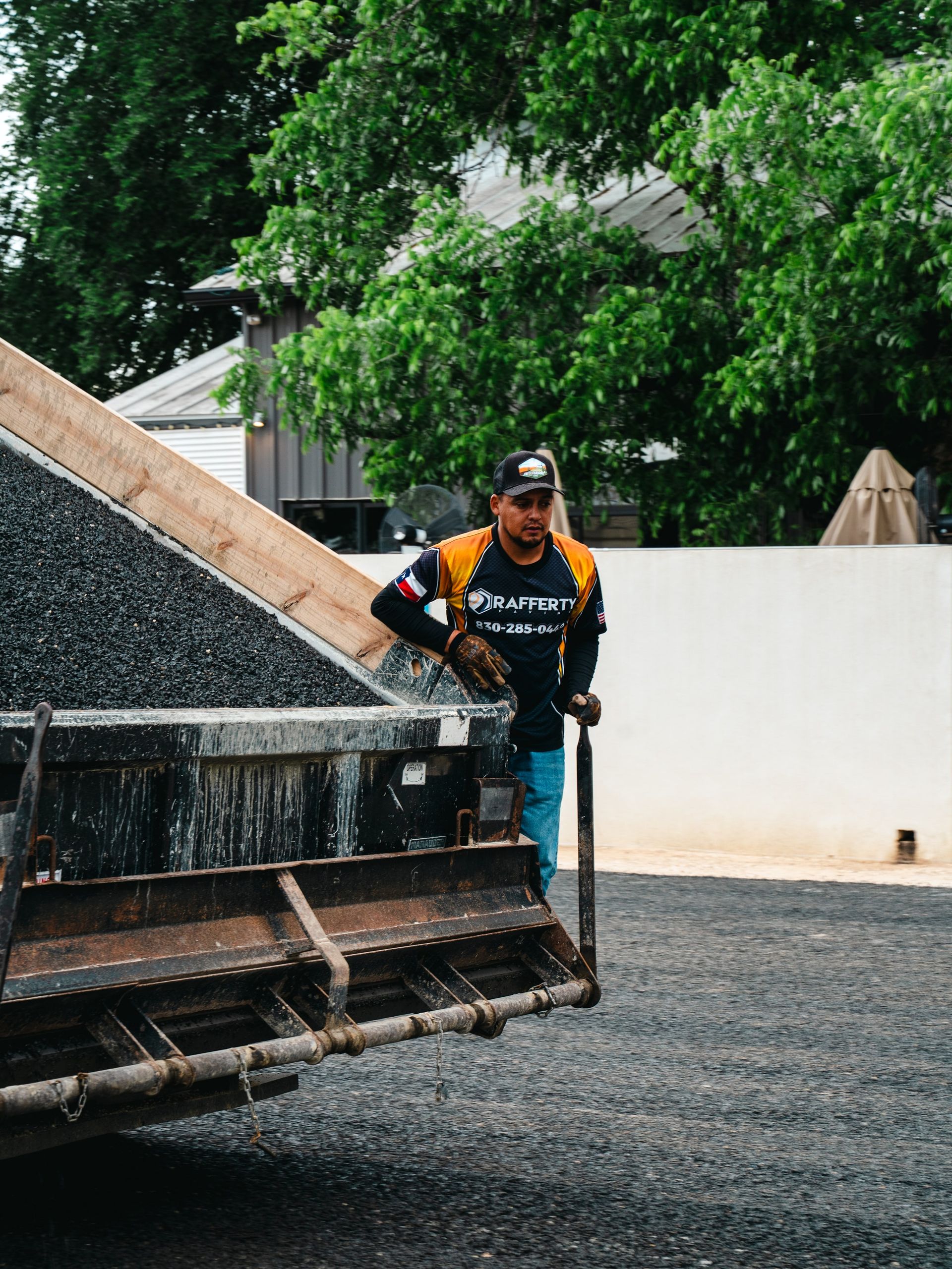 Worker monitoring fresh aggregate placement during chip-seal work