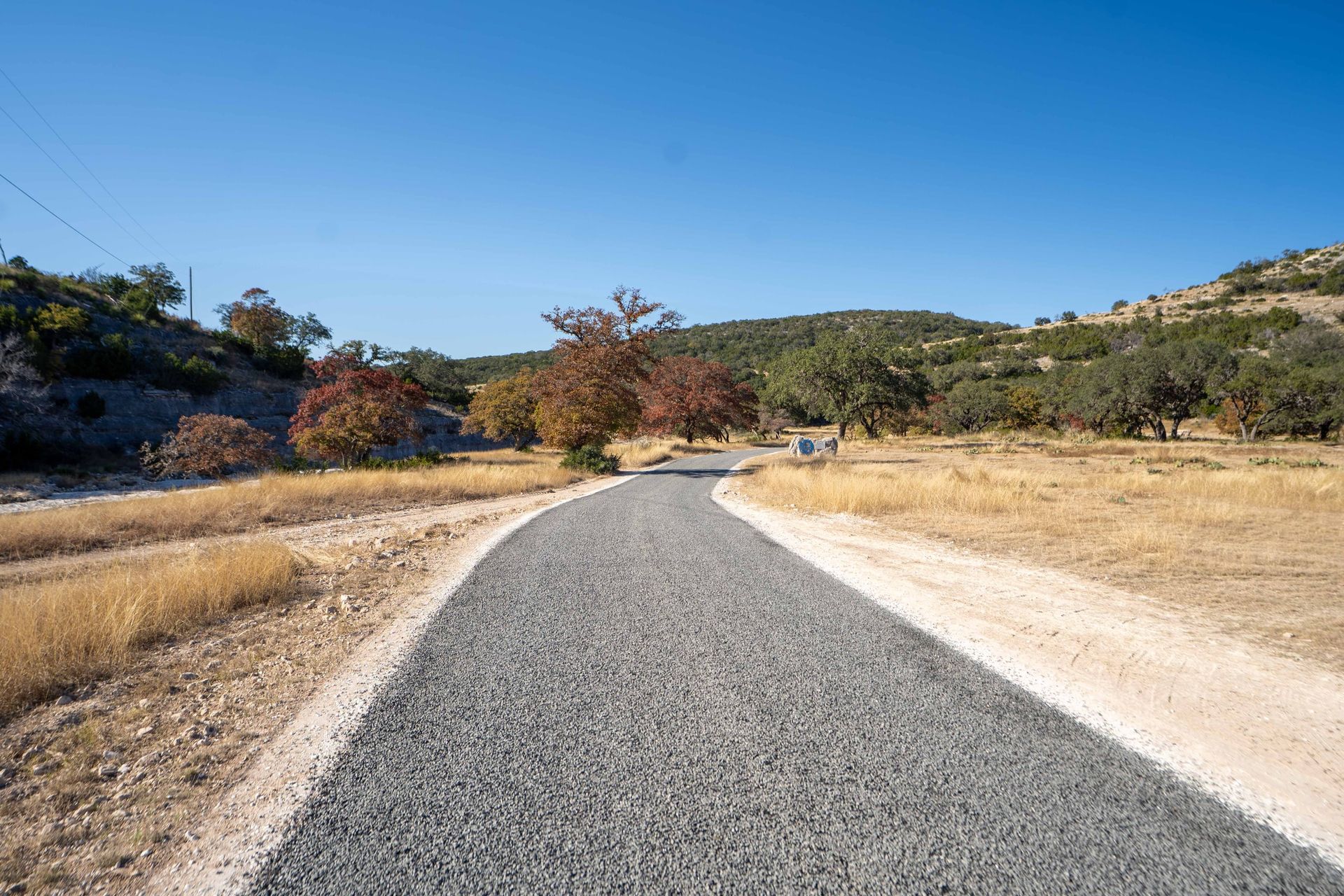 Finished rural road rising through open country