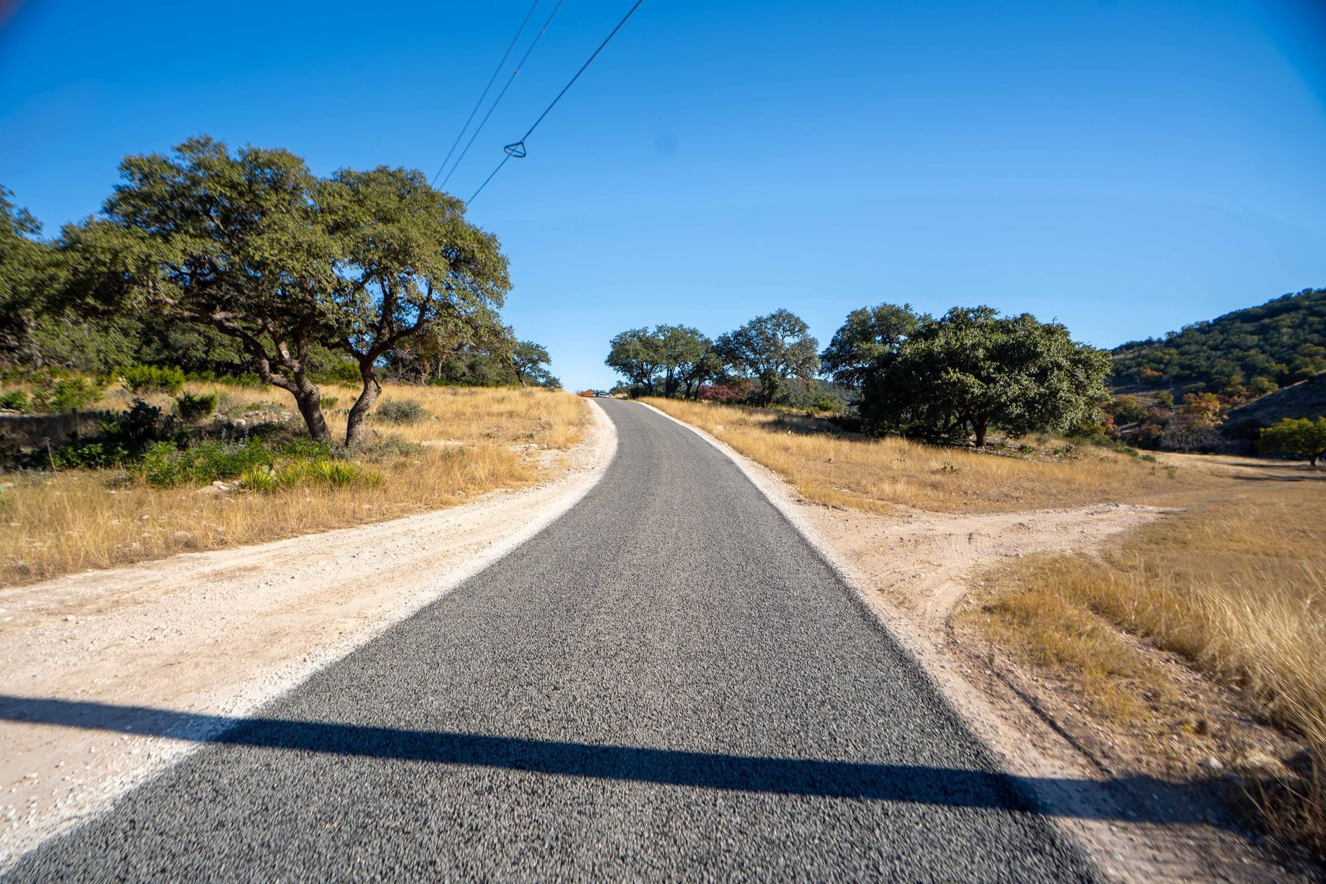 Finished rural road crossing open wooded land
